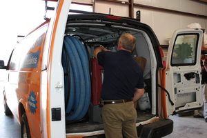 Water Damage Restoration Technician Prepping Van At Warehouse